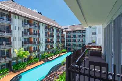 an apartment building with a swimming pool and a balcony at Fairfield by Marriott Bali Kuta Sunset Road in Kuta