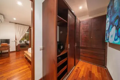a room with a wooden closet and a bedroom at Villa Rubina - Luxury Pool Villa in Batu Belig Next to the Beach! in Seminyak