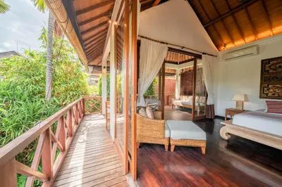 a room with a balcony with a bed and a bed and a desk at Villa Rubina - Luxury Pool Villa in Batu Belig Next to the Beach! in Seminyak