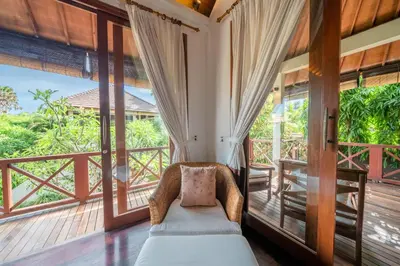 a bedroom with a bed and a balcony with windows at Villa Rubina - Luxury Pool Villa in Batu Belig Next to the Beach! in Seminyak