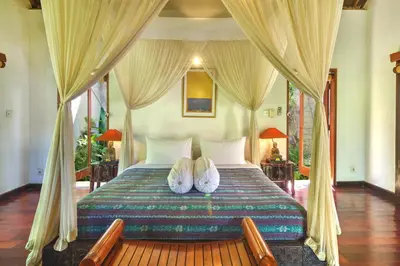 a bedroom with a bed with two pillows on it at Villa Plawa Asri in Seminyak