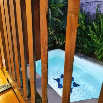 a swimming pool through a wooden fence at Villa BAgus - near Seminyak beach & trendy shops, restaurants, cafes in Seminyak