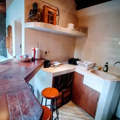 a kitchen with a counter and a sink and a stool at Villa BAgus - near Seminyak beach & trendy shops, restaurants, cafes in Seminyak