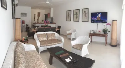 a living room with couches and chairs and a table at Hevea Villas in Seminyak