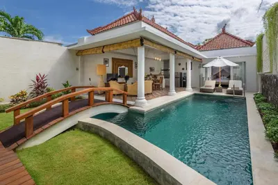 a house with a swimming pool and a wooden bridge at Hevea Villas in Seminyak