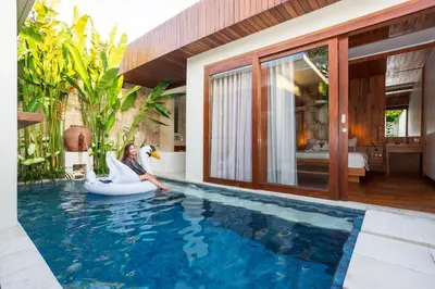 a woman sitting on an inflatable pool in a house at Bali Vilaasee in Seminyak