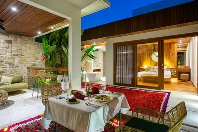 a patio with a table and chairs and a bedroom at Bali Vilaasee in Seminyak