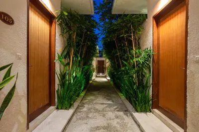 a hallway with plants on the sides of a building at Bali Vilaasee in Seminyak