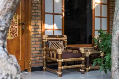 a porch with two chairs and a wooden door at Sanur Lodge in Sanur