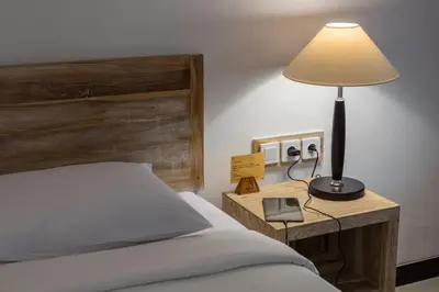 a bedroom with a bed and a lamp on a table at Sanur Lodge in Sanur