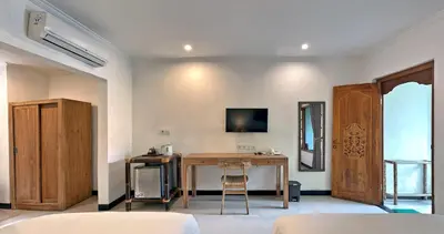 a room with a wooden table and a desk at Sanur Lodge in Sanur