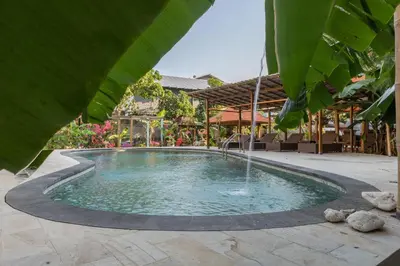a pool with a fountain in the middle of a patio at Sanur Lodge in Sanur
