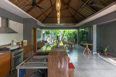 an open kitchen with an island in the middle at Balinea Holiday Home in Kerobokan