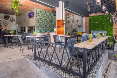 a restaurant with tables and chairs in a room at Gemini Star Hotel Kuta in Kuta