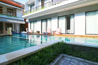 a swimming pool in front of a building at Gemini Star Hotel Kuta in Kuta