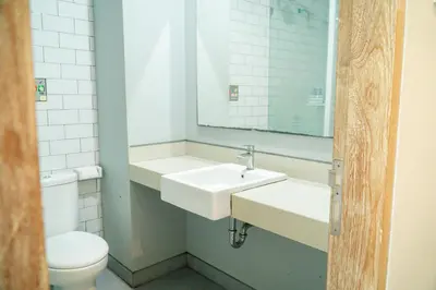 a bathroom with a sink and a toilet and a mirror at Gemini Star Hotel Kuta in Kuta