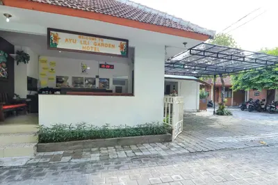 a white building with a sign that reads no hot chicken hotel at Ayu Lili Garden Hotel Kuta in Kuta