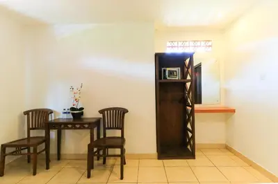 a dining room with a table and chairs and a mirror at Ayu Lili Garden Hotel Kuta in Kuta
