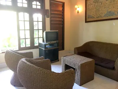 a living room with wicker chairs and a television at Sari Bali Resort in Kuta