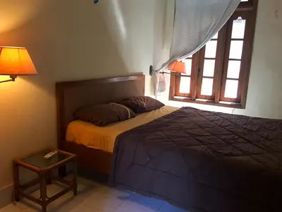 a bedroom with a bed and a window at Sari Bali Resort in Kuta