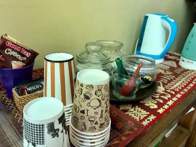 a table with cups and other items on it at Guest house KupuKupu39 in Kuta