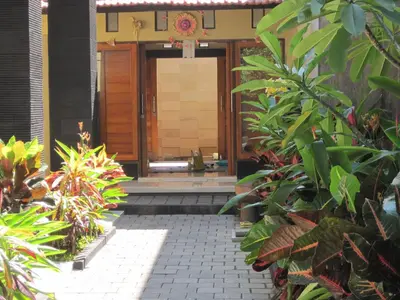 a front door of a house with plants at Guest house KupuKupu39 in Kuta