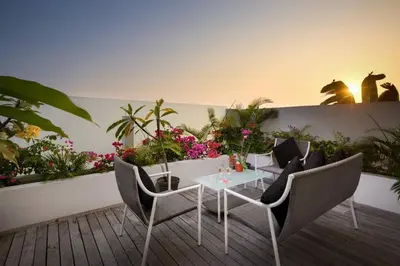 a patio with a table and chairs and flowers at Villa Miro - Luxury, 3 Bed, Central Seminyak in Seminyak