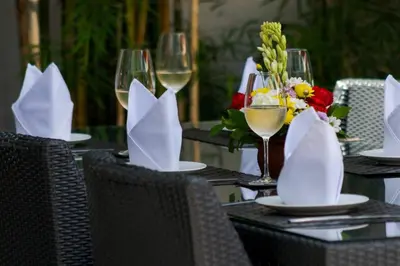 a table with glasses of wine and flowers on it at Villa Miro - Luxury, 3 Bed, Central Seminyak in Seminyak