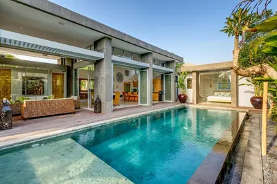 an indoor swimming pool in front of a house at Aramanis in Seminyak