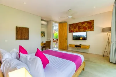 a bedroom with a large bed with pink pillows at Aramanis in Seminyak