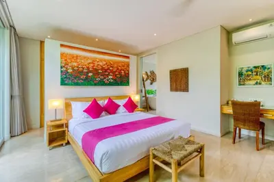 a bedroom with a large bed with pink pillows at Aramanis in Seminyak
