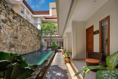 an indoor pool with plants and a stone wall at Angkul Angkul Segara Beach Kuta by Kamara in Kuta
