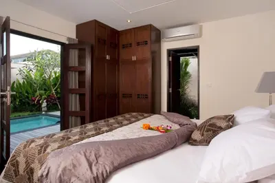 a bedroom with a bed and a pool at Elok Villas in Seminyak