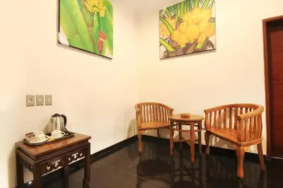 two chairs and a table in a room at Letos Kubu Homestay in Kuta