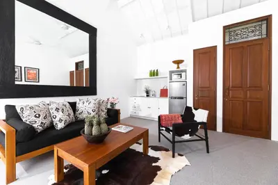 a living room with a black couch and a table at Villa Salsa in Seminyak