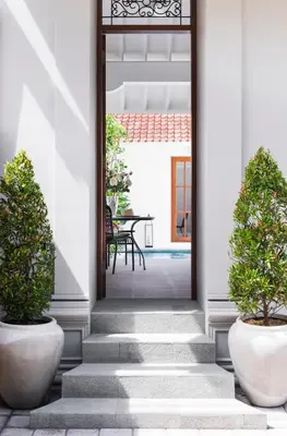 a hallway with two potted plants next to a door at Villa Salsa in Seminyak