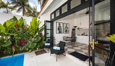 a patio with black and white tiles and plants at Villa Chino in Seminyak