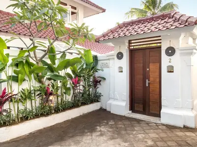 a house with a wooden door in front of it at Villa Umara by Villa Finder in Seminyak