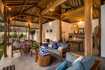 an outdoor living room with couches and a kitchen at Villa Nakal by Alfred in Bali in Seminyak