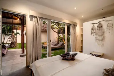 a bedroom with a white bed and a patio at Villa Nakal by Alfred in Bali in Seminyak