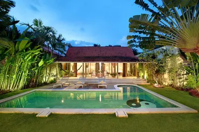 a swimming pool in front of a house at Villa Balimasan 10 mins to Canggu in Seminyak