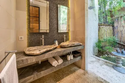 a bathroom with two sinks and a mirror at Villa River Garden Canggu in Kerobokan