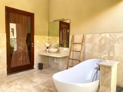 a large bathroom with a tub and a sink at Three Brothers Bali Legian Bungalows & Villas in Legian