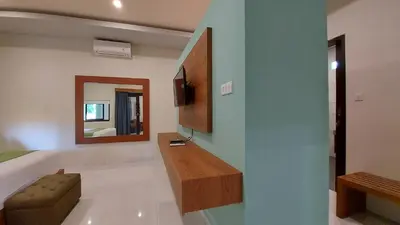 a living room with a sink and a mirror at The New Moon Seminyak in Seminyak