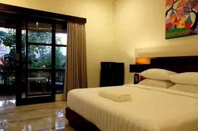 a bedroom with a large bed and a window at The New Moon Seminyak in Seminyak