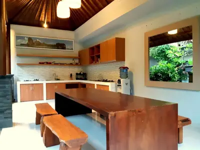 a kitchen with a large wooden table and benches at The New Moon Seminyak in Seminyak