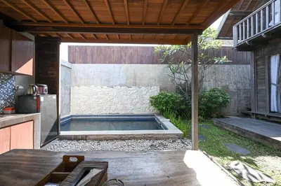 a swimming pool in the middle of a backyard at Hoki Villa by Urbanview Villa in Kerobokan