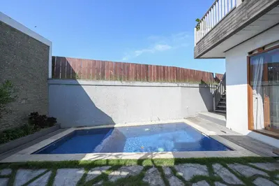 a swimming pool in the courtyard of a house at Hoki Villa by Urbanview Villa in Kerobokan