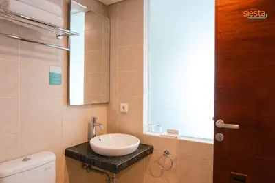 a bathroom with a sink and a toilet and a window at Siesta Legian in Legian