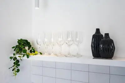 a row of wine glasses sitting on a shelf with vases at Villa Saffron in Seminyak